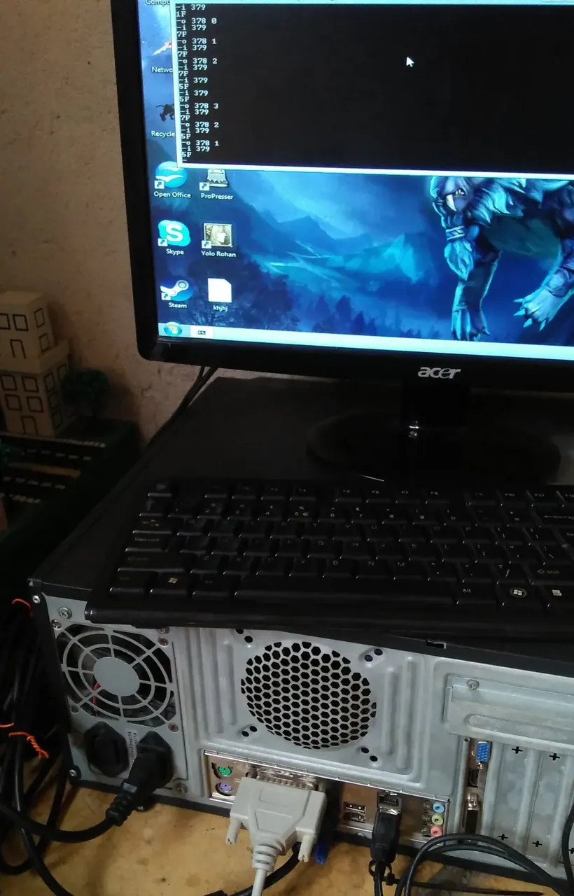 An old desktop PC with a 25-pin parallel cable plugged into its back panel; on the monitor, a DEBUG session writing to port 378 and reading back from port 379